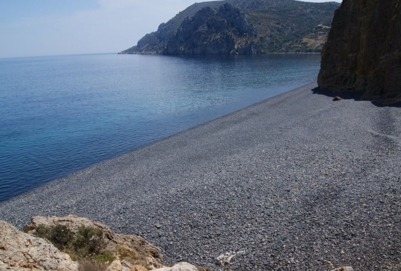 Ζαφειρένια νερά και μαύρα βότσαλα: Η εξωπραγματική παραλία ελληνικού νησιού με την χρωματική αντίθεση που ξεχωρίζει